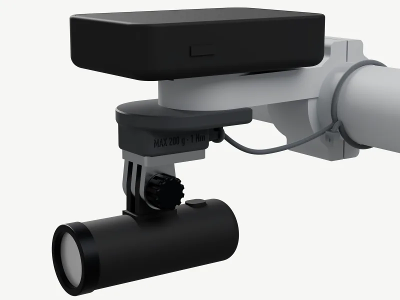 Render grafitowej płytki przykręconej pod gniazdem szarego aluminiowego uchwytu z wysięgnikiem, z licznikiem wielkości Edge'a 840 na górze, 10 mm występem pod przodem płytki z aluminiowym adapterem GoPro i małą lampką oraz linką od tylnej krawędzi płytki wokół kierownicy.