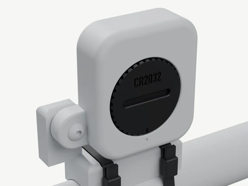 Render from the front: a clay-grey Sigma STS-style sensor zip-tied to a tube, our black cap in its battery well with a fluted rim, CR2032 above a horizontal coin slot and a tick lined up with a dot on the sensor.
